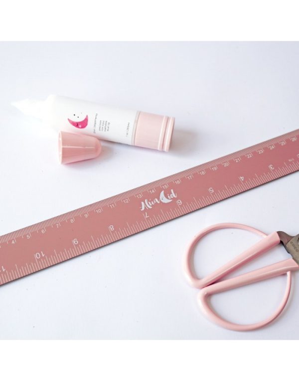 Regla 30 cm rosa, de Alúa Cid. Es metálica y lleva medidas en cm y pulgadas