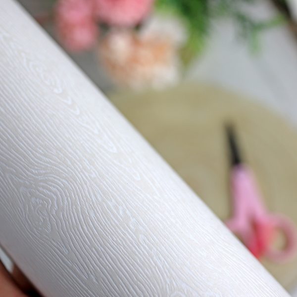 Cartulina con textura de madera blanco roto.